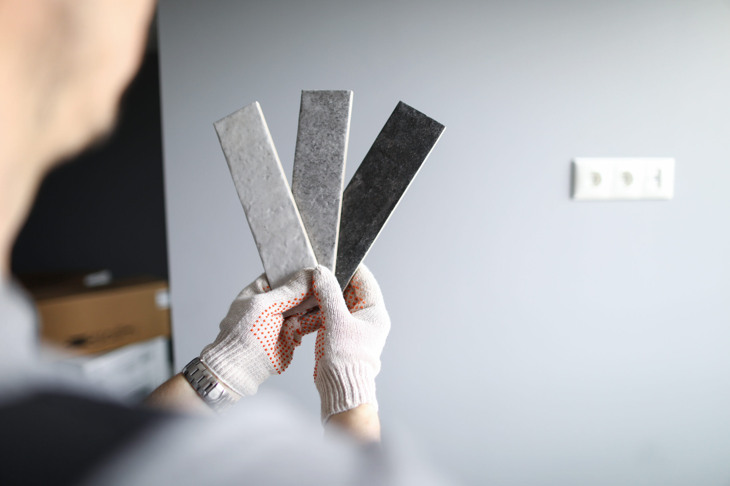 Person holding swatches of rough textured walls